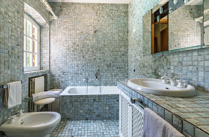 Bagno con mosaico azzurro e vasca