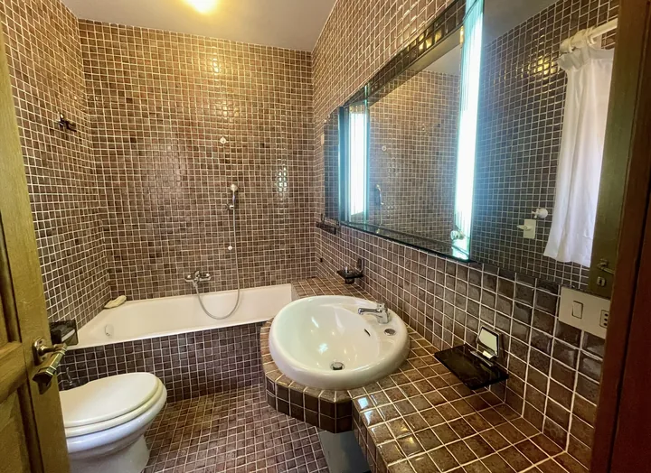 Bagno con vasca e mosaico scuro